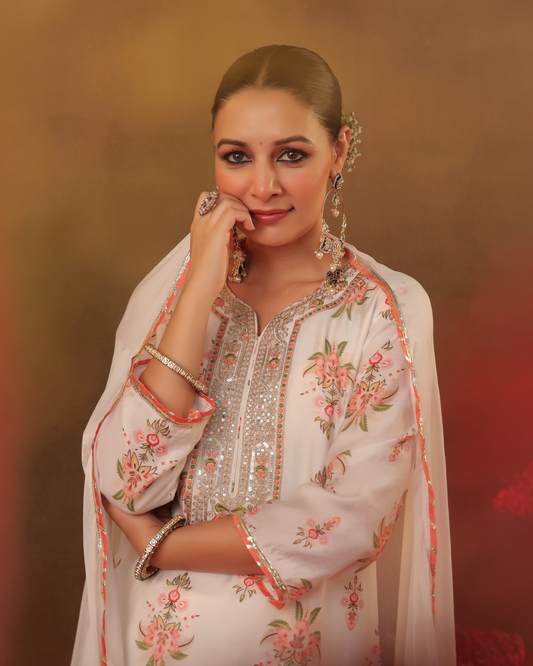 Woman in traditional embroidered outfit with floral patterns on a warm-toned background